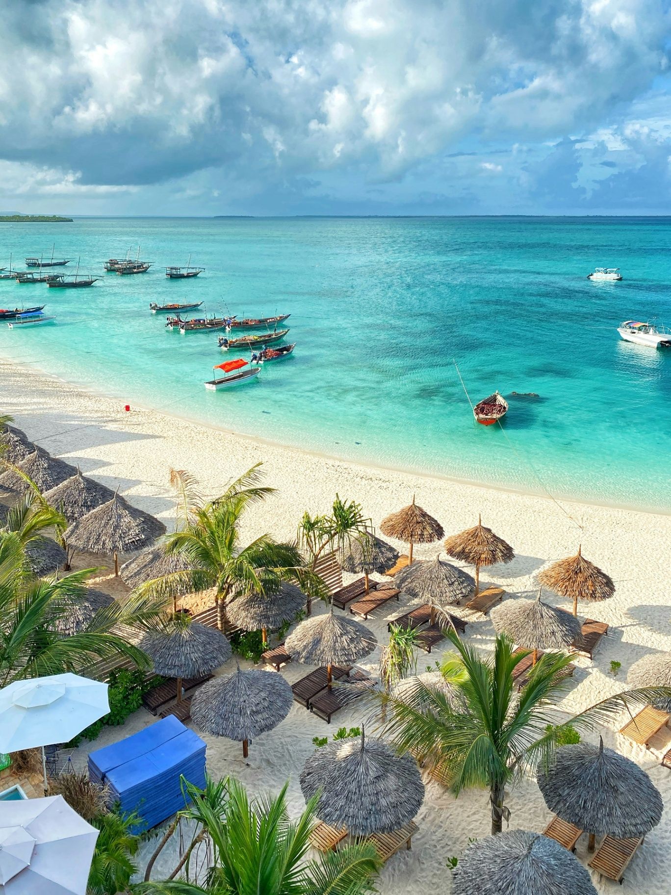 View over a Zanzibar beach with straw umbrellas and turquoise water